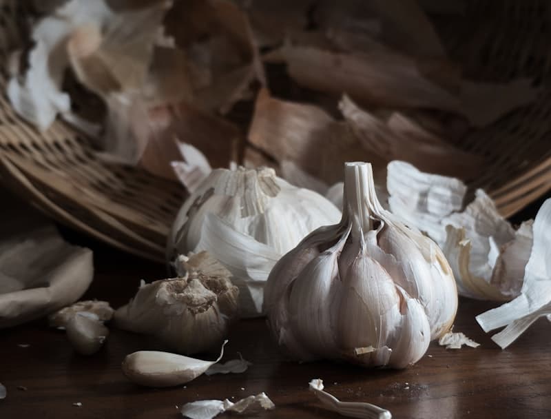 Dehydrated garlic flakes spilling from a glass jar